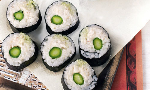 A plate of green asparagus rolls with soy sauce